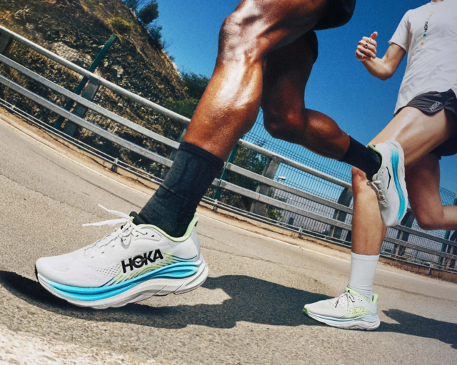 Runners in HOKA shoes on a road, representing Start Fitness customers who now collect orders via HubBox's OOH pickup network.
