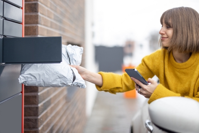 Woman collecting a parcel from an outdoor pickup locker